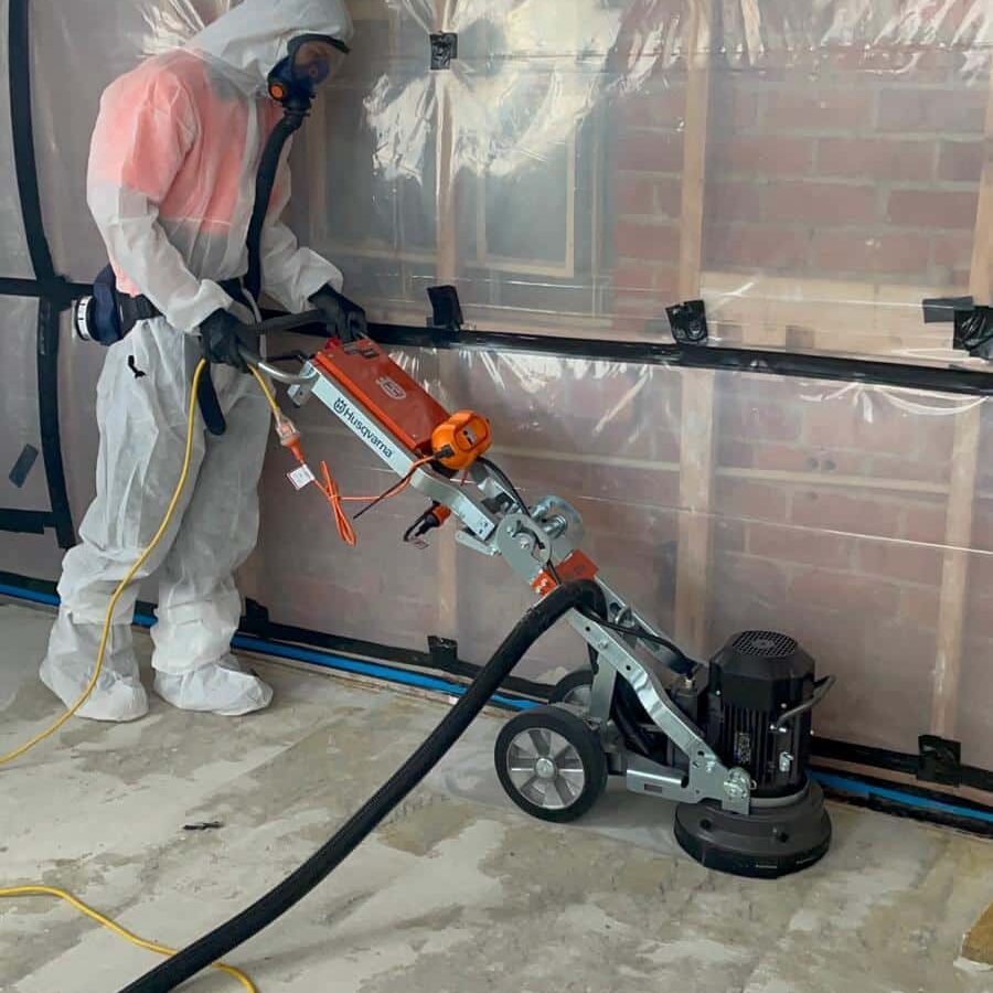 Removing asbestos glue with a concrete grinder