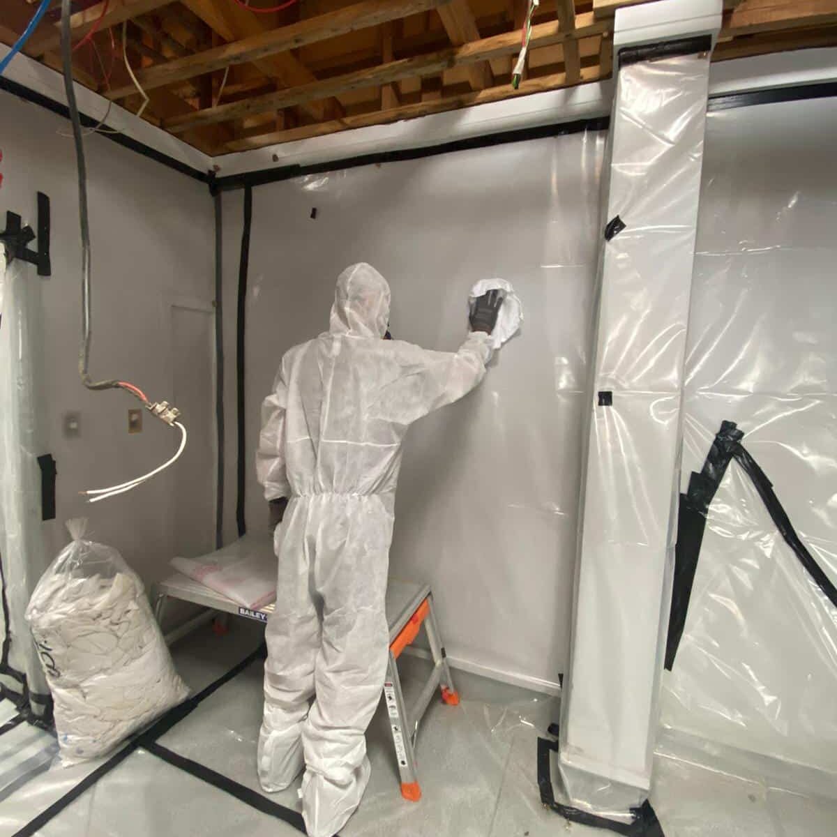 Worker clad in protective clothing performs Class B Asbestos removal
