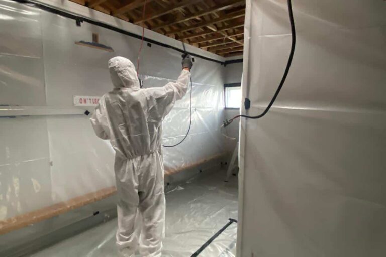 A worker in full safety suit and mask undertakes Class B Asbestos removal